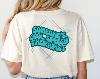 Può includere: T-shirt color crema con la scritta turchese "SOMEONE'S COOL SPEECH THERAPIST" su un design geometrico turchese. La maglietta a maniche corte ha una vestibilità ampia, ideale per l'uso quotidiano.
