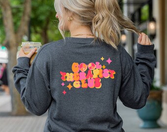 May include: A dark grey long-sleeved sweatshirt featuring the text "COOL THERAPIST CLUB" in a retro font on the back. The text is in orange, pink, and yellow with star accents. The sweatshirt is a casual style.