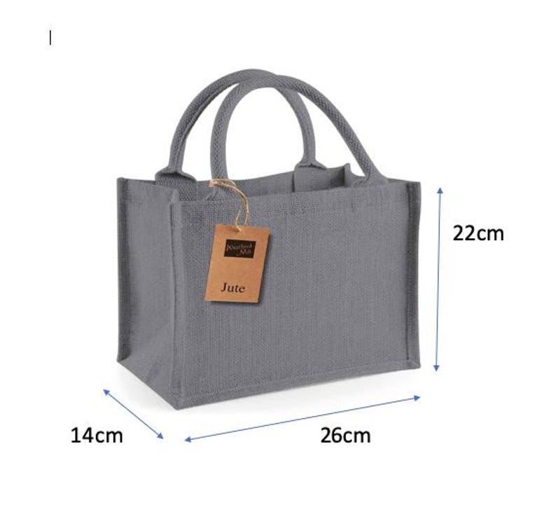 May include: A grey rectangular jute tote bag with two rounded handles and a brown paper tag attached by a string. The tag features the text Westford Mill and Jute. The bag measures 26 cm in length, 14 cm in width, and 22 cm in height.