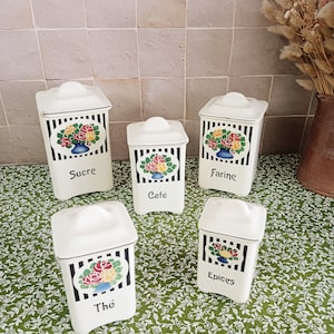 Puede incluir: Conjunto de cinco botes de cerámica blanca con rayas blancas y negras y diseños florales. Los botes están etiquetados con "Sucre", "Café", "Farine", "Thé" y "Epices".