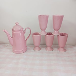 Puede incluir: Un juego de seis tazas de té de cerámica rosa y una tetera rosa a juego. Las tazas tienen una base con pie y son perfectas para servir té o café.
