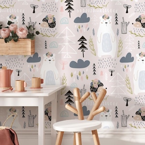 May include: A nursery scene with light pink wallpaper patterned with white bears, hedgehogs, trees, and clouds. A white table holds a teapot, cups, and a basket with a pink blanket. A wooden chair with a deer antler back is in the foreground.