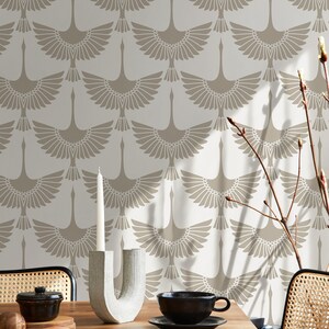 May include: A dining table setting with a black teacup and saucer, a decorative candle holder, and a wallpaper backdrop. The wallpaper features a repeating pattern of stylized birds in beige and cream tones, creating a cohesive aesthetic.