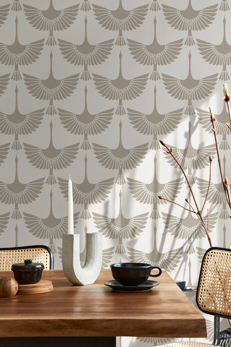 May include: A dining table setting with a black teacup and saucer, a decorative candle holder, and a wallpaper backdrop. The wallpaper features a repeating pattern of stylized birds in beige and cream tones, creating a cohesive aesthetic.