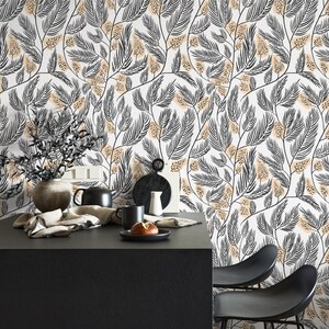 May include: A black and white floral wallpaper with a beige background. The wallpaper features a repeating pattern of stylized leaves and flowers. The wallpaper is shown in a kitchen setting with a black table and chairs.