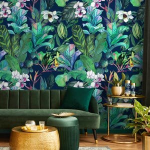 May include: A living room with a dark green sofa, a gold coffee table, and a small side table. The wall is covered in a vibrant tropical wallpaper featuring green leaves, white orchids, and other colorful plants against a dark blue background.
