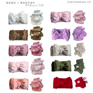 May include: A collection of baby headbands and booties in various colors, including white, brown, pink, purple, beige, green, and red. The headbands feature large bow details, and the booties have a ruffled design. The text "BOWS + BOOTIES" and "100% Organic Cotton" are visible.