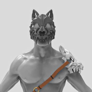 May include: A gray wolf skull mask with detailed teeth and ear structures. A white shoulder piece with a wolf skull design is connected to a brown strap with a gold ring. The overall theme is fantasy or cosplay.