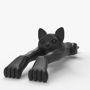 May include: A black cat-shaped doorstop. The doorstop is lying down with its front paws extended. The cat has large ears, round eyes, and a small nose. The doorstop is made of a solid material and has a matte finish.