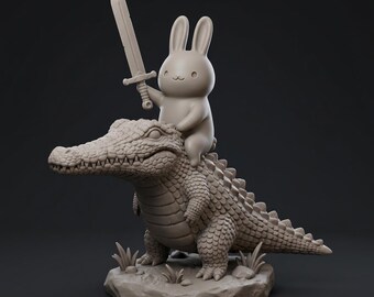 Könnte beinhalten: Eine skurrile Skulptur eines Cartoon-Kaninchens, das auf einem Alligator reitet und ein Schwert hält. Das Kaninchen ist hellbraun, mit langen Ohren und einem lächelnden Gesicht. Der Alligator ist detailliert mit strukturierten Schuppen und Zähnen. Die Skulptur steht auf einem kleinen Felsensockel.