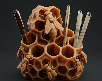 Könnte beinhalten: Ein hölzerner Schreibtisch-Organizer in Form einer Honigwabe, mit geschnitzten Bienen und Fächern für Stifte und Bleistifte. Der Organizer hat einen warmen, honigfarbenen Farbton, mit einem Stift und Bleistiften in den Schlitzen. Das Design ist aufwendig und von der Natur inspiriert.