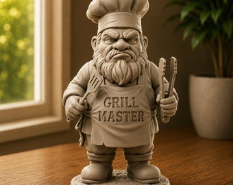 May include: A monochromatic beige figurine of a bearded chef wearing a tall hat and an apron with the text GRILL MASTER embossed on the front. The figure holds a spatula in the right hand and a pair of metal tongs in the left hand.