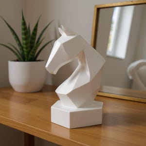May include: A white geometric horse sculpture with a modern design. The sculpture is made of a solid material and sits on a square base. The horse head is angled, and the sculpture is displayed on a wooden surface.