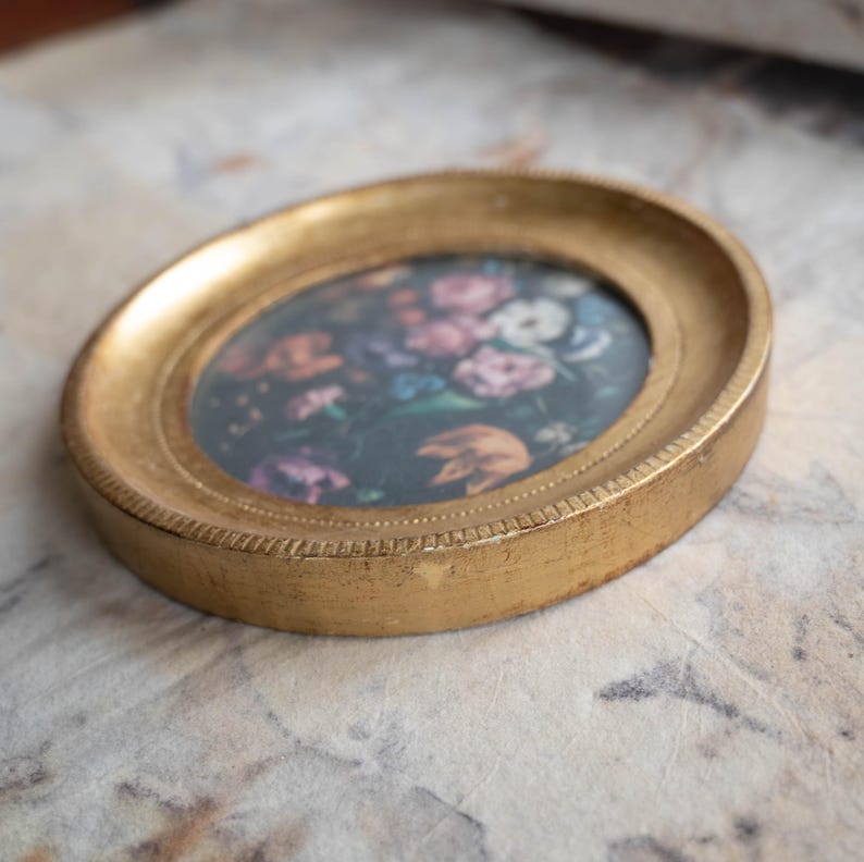 Wide angled perspective of the vintage wood wall picture frame resting flat on a marble-patterned surface.