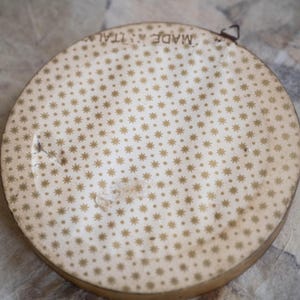 May include: A round, white, decorative plate with a gold star pattern and the text "Made in Italy" printed on the back.