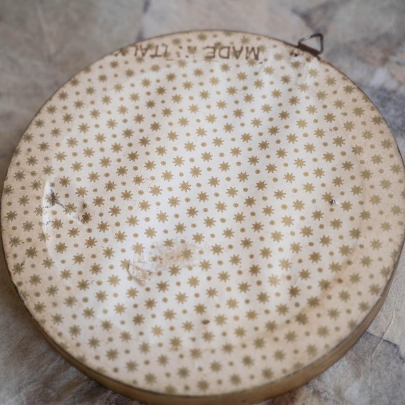 May include: A round, white, decorative plate with a gold star pattern and the text "Made in Italy" printed on the back.