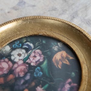 Close-up top angle of the vintage wood wall picture frame displaying the intricate floral artwork inside.