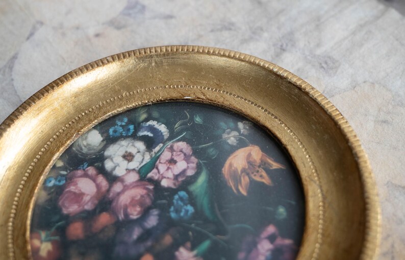 Close-up top angle of the vintage wood wall picture frame displaying the intricate floral artwork inside.