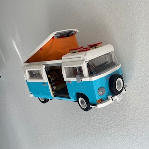 May include: A blue and white LEGO camper van with a pop-up roof and a red license plate that says "K.W. 702A".