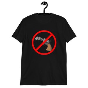 May include: Black t-shirt featuring a cartoon image of a revolver crossed out with a red circle and line. The revolver has a brown handle and a silver barrel. The shirt is hanging on a black hanger.