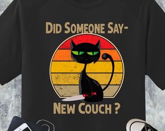 Puede incluir: Camiseta negra con un gráfico de estilo vintage de un gato negro sosteniendo un cuchillo. El gráfico dice "Did someone say- New Couch?"