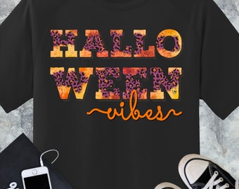 Op de afbeelding: Zwart T-shirt met een oranje en paars luipaardprintontwerp met de tekst "Halloweeen vibes".