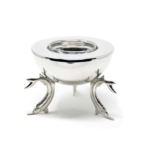 May include: Silver egg-shaped salt cellar with three fish-shaped legs. The top of the cellar has a removable lid.
