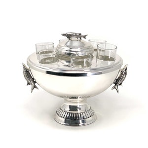 May include: Silver ice bucket with a lid and four shot glasses. The ice bucket has fish-shaped handles.