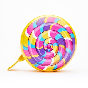 May include: A yellow bicycle bell with a colorful swirl design resembling a lollipop. The bell has a bright pink, blue, and yellow swirl pattern.