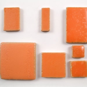 May include: Assortment of six orange ceramic tiles in various sizes and shapes. The tiles have a slightly textured surface.