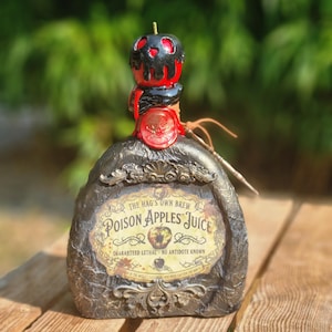 Può includere: Una bottiglia di vetro decorativa con finitura scura testurizzata, con un'etichetta che recita THE HAG'S OWN BREW POISON APPLES JUICE GUARANTEED LETHAL - NO ANTIDOTE KNOWN. Il tappo è una mela rossa coperta di liquido nero con un sigillo di ceralacca.