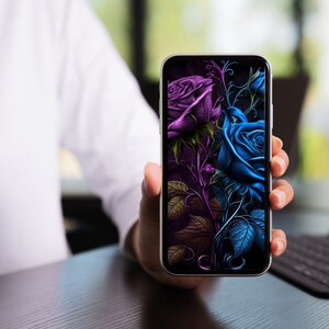May include: A smartphone displaying a digital illustration of two roses, one purple and one blue, with intricate details and a dark background.