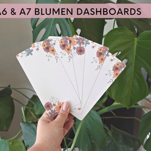 Könnte beinhalten: Ein Satz von fünf floral gemusterten A6- und A7-Dashboards. Die Dashboards sind weiß mit einem Rand aus orangefarbenen, roten und blauen Blumen.