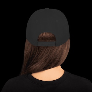 May include: A black baseball cap with a black adjustable strap in the back. The strap has the word "RECKLESS" printed on it.