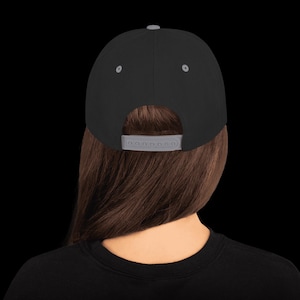 May include: A black and gray baseball cap with a gray adjustable strap in the back.