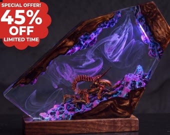 May include: A rectangular lamp featuring a brown wooden base and a clear resin block containing a brown creature figure. The resin is illuminated with purple light and swirling smoke-like patterns. A red circular badge displays the text 45% OFF.