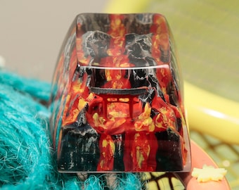 Op de afbeelding: Een transparante hars toetsenkap met een zwart en rood ontwerp met een Japanse tempelpoort. Het ontwerp doet denken aan een vurig landschap.