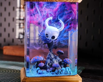 Puede incluir: Una lámpara de resina transparente con una base de madera. La lámpara presenta una figura 3D de un caballero sobre un fondo azul y morado brillante. La base de la lámpara tiene el texto "BreakWooden".