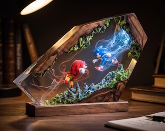 May include: A rectangular resin and wood display piece featuring miniature figures of Sonic the Hedgehog and Knuckles the Echidna. The blue and red characters are suspended within clear resin, surrounded by green textured terrain and wispy trails.