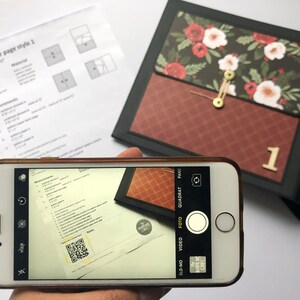 Puede incluir: Primer plano de un tel&eacute;fono inteligente que muestra un documento con un c&oacute;digo QR. El documento tiene el texto "Measurements" y una lista de n&uacute;meros. El tel&eacute;fono inteligente est&aacute; en la mano de una persona, pero la mano no es visible en la imagen.