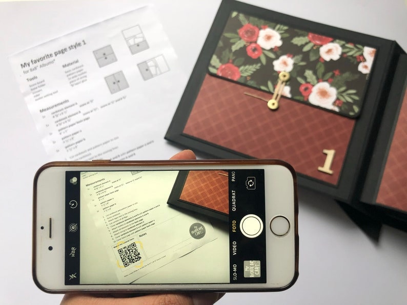 Puede incluir: Primer plano de un tel&eacute;fono inteligente que muestra un documento con un c&oacute;digo QR. El documento tiene el texto "Measurements" y una lista de n&uacute;meros. El tel&eacute;fono inteligente est&aacute; en la mano de una persona, pero la mano no es visible en la imagen.