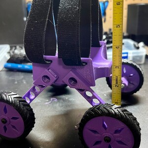 May include: Purple 3D printed toy car with black velcro straps, four wheels, and a measurement tape showing 6 inches in height.