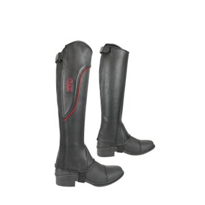 May include: A pair of black leather riding boots with red stitching and a red "GAX" logo. The boots have a zipper on the inside of the leg and a strap with a buckle at the ankle.