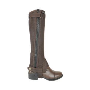 May include: Brown equestrian half chaps with a full-length zipper and a buckle closure. The chaps are made of a durable material and are designed to protect the lower leg. The chaps are shown with a brown leather riding boot.