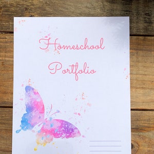 Może przedstawiać: Biała okładka z tekstem "Homeschool Portfolio" napisanym r&oacute;żowym kursywą. W lewym dolnym rogu znajduje się akwarelowy motyl w kolorze r&oacute;żowym, niebieskim i ż&oacute;łtym. Na dole strony znajdują się trzy linie.
