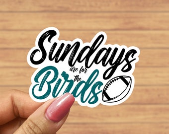May include: A white sticker with black and teal lettering that reads "Sundays are for the Birds" with a black and white football graphic.