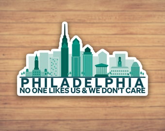 May include: A sticker with a green and white silhouette of the Philadelphia skyline. The text "PHILADELPHIA NO ONE LIKES US & WE DON'T CARE" is printed below the skyline.