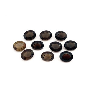 Ten oval faceted natural smoky quartz loose gemstones arranged in a cluster. They are shades of brown ranging from light to dark and would be perfect for making a piece of jewellery. Picture taken from the top on a white background.