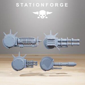 May include: Four different views of a gray plastic 3D printed model of a futuristic weapon. The weapon has a large circular base with spikes and a long barrel with multiple barrels.