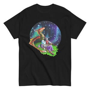 May include: A black t-shirt with a colorful illustration of a red dragon, a wizard, and a young person looking up at a starry sky. The illustration is surrounded by a circle.